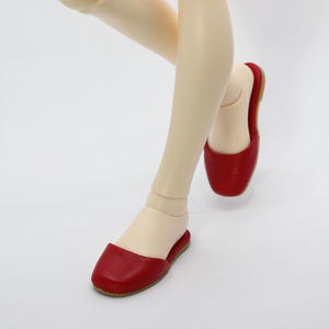 Peut inclure: Une paire de chaussures à enfiler en cuir rouge avec une pointe pointue.