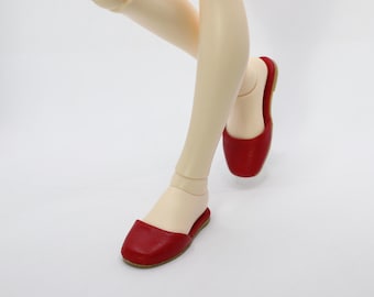 May include: A pair of red leather slip-on shoes with a pointed toe.