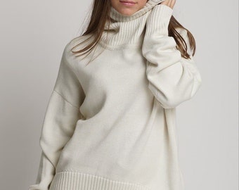 May include: A white turtleneck sweater with long sleeves and a ribbed hem.