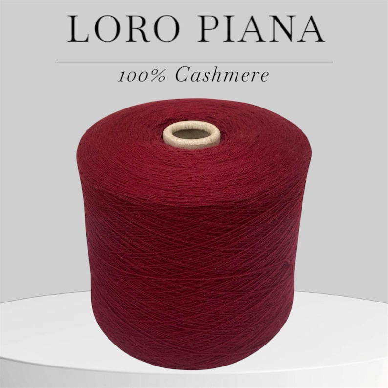 Op de afbeelding: Een spoel met donkerrode kasjmiergaren, met het label "LORO PIANA 100% Kasjmier".