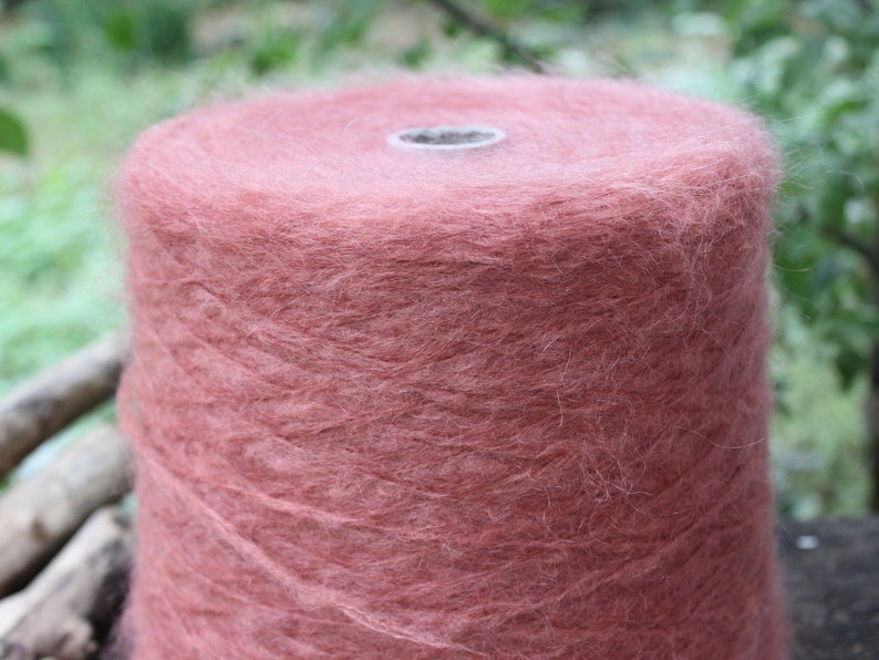 Op de afbeelding: Een close-up van een bol zachte, pluche garen in een stoffige roze kleur.
