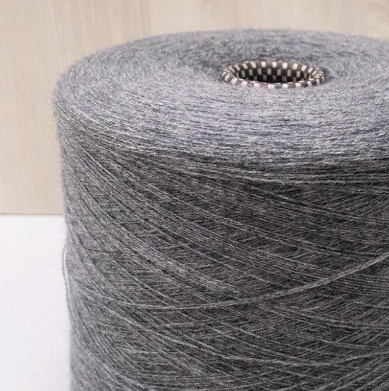 May include: A skein of dark gray yarn wound on a cardboard spool.