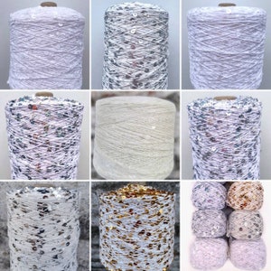 以下が含まれることがあります： 白の糸巻きにスパンコールがついた糸の詰め合わせ。糸はシルバー、ゴールド、虹色があります。