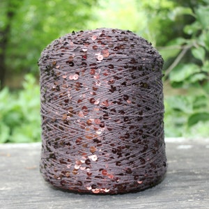 May include: A spool of brown yarn with copper-colored sequins woven throughout.