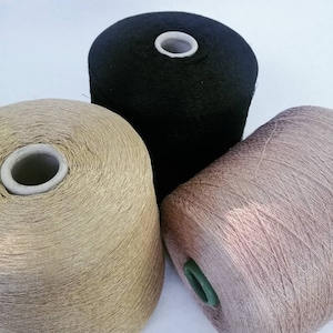 May include: Three spools of yarn in black, gold, and light brown.