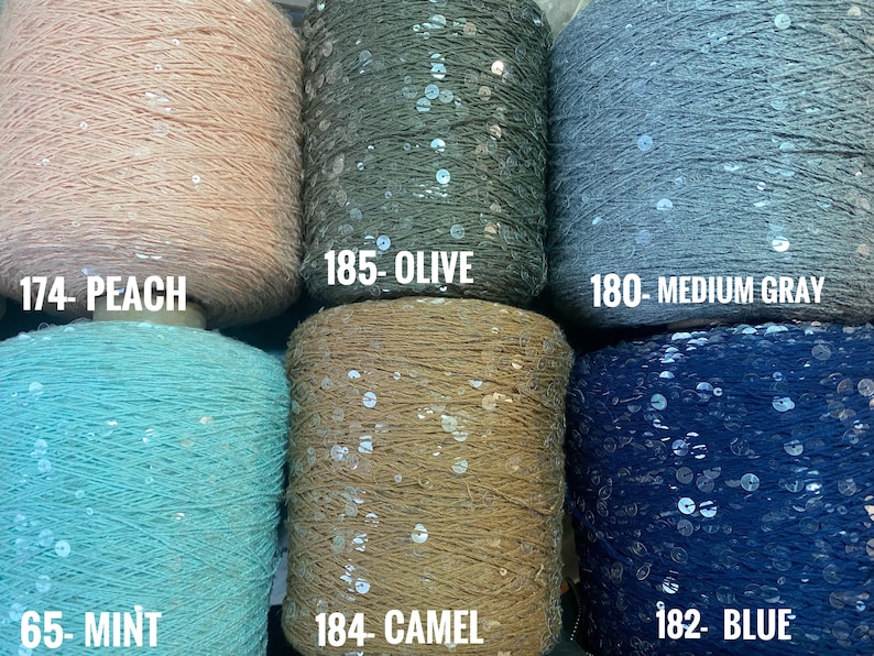 May include: Six spools of yarn with sequins, in colors peach, olive, medium gray, mint, camel, and blue. Each spool has a label with a number and color name.