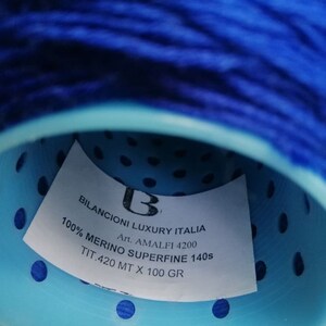 May include: A blue ball of yarn with a white label that reads "BILANCIONI LUXURY ITALIA B Art. AMALFI 4200 100% MERINO SUPERFINE 140s TIT.420 MT X 100 GR".