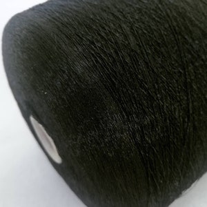 May include: A close-up of a spool of black thread.