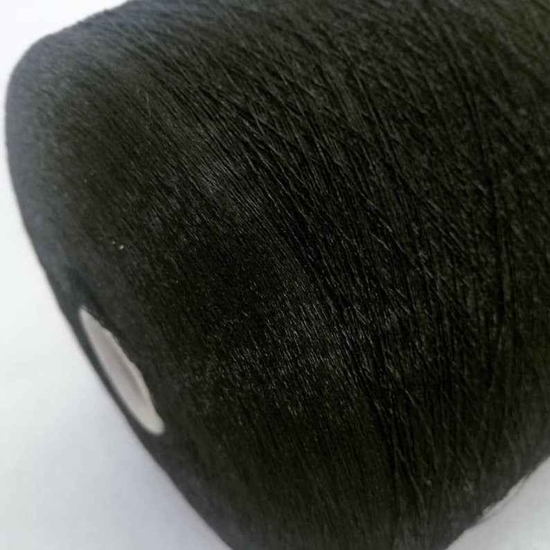 May include: A close-up of a spool of black thread.