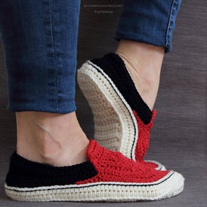 May include: Crocheted slippers in red, black, and white with a white sole. The slippers are made to look like sneakers.