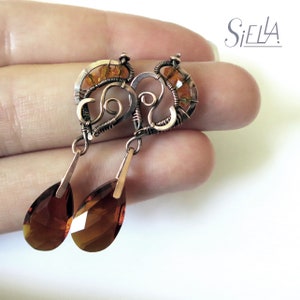 Peut inclure: Boucles d'oreilles en fil de cuivre avec un motif en spirale et des cristaux ambr&eacute;s en forme de goutte.