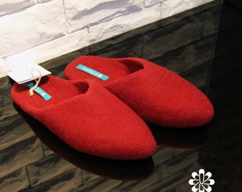 May include: A pair of red wool slippers with a teal label that says "artslippers".