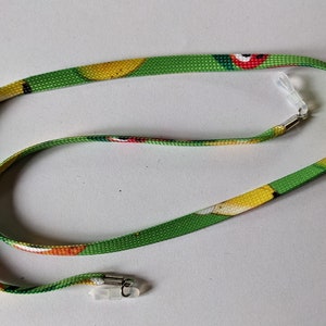 May include: A green, yellow and red patterned eyeglass chain with clear plastic clasps at each end.