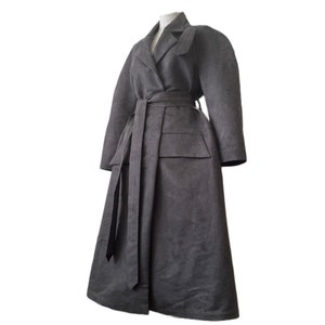 May include: A long, dark gray coat with a belt and a large pocket on the front.