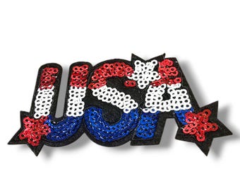 Peut inclure: Un patch en sequins rouge, blanc et bleu avec le mot "USA" et deux étoiles. Le patch est en feutre et a un dos noir.