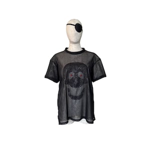 May include: Black mesh shirt with a skull graphic and red eyes. The shirt has a loose fit and a scoop neck.