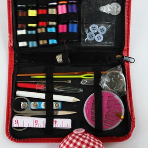 May include: A red zippered sewing kit containing a range of sewing supplies, including thread, needles, pins, buttons, a thimble, a tape measure, and a pincushion.