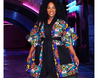 May include: A black kimono with a colorful geometric pattern. The kimono has a belt and pockets. The pattern is in shades of blue, red, yellow, and white.
