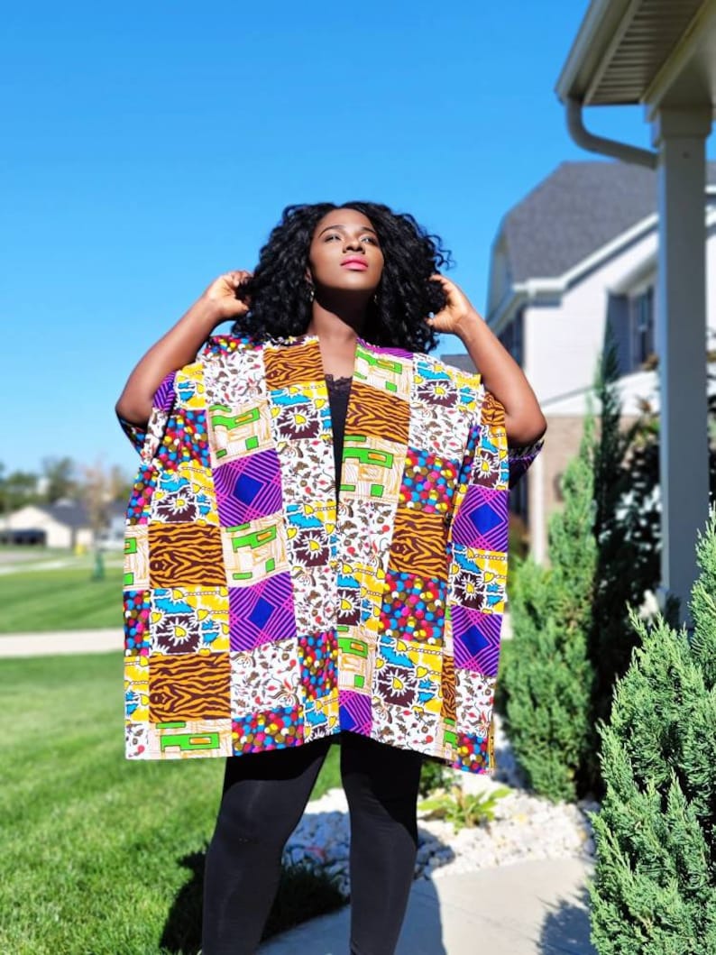May include: A patchwork kimono featuring a variety of patterns and colours, including zebra print, polka dots, and geometric shapes. The open-front design is worn over a black top and leggings.
