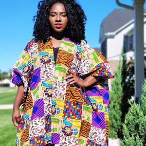 May include: A colourful patchwork kimono with a mix of patterns in purple, yellow, and brown. The garment has wide sleeves and a relaxed fit. The kimono is ideal for layering and features a variety of geometric and floral designs.