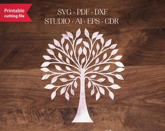 May include: A white paper tree design with detailed leaves and branches, suitable for laser cutting. The image includes the text "Printable cutting file" and file type options: SVG, PDF, DXF, STUDIO, AI, EPS, and CDR. The design is set against a wood grain background.