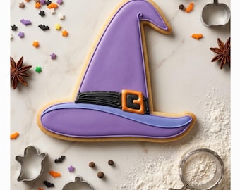 May include: A witch hat-shaped sugar cookie decorated with purple icing, a black band, and an orange buckle. The cookie is surrounded by star-shaped sprinkles, star anise, metal cookie cutters in ghost and pumpkin shapes, and flour.
