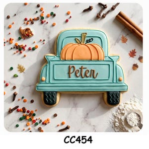 Peut inclure: Un biscuit en forme de camion bleu clair décoré d'une citrouille orange dans la benne et du prénom Peter écrit en glaçage marron. Le biscuit présente des pneus noirs et est entouré de vermicelles, de clous de girofle et de cannelle.