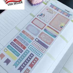 May include: A sheet of planner stickers with various designs, including rectangles, banners, and labels. The stickers feature pastel colours, hearts, and text like "TO DO" and "GOALS." A small unicorn and the words "make wish" are also visible.