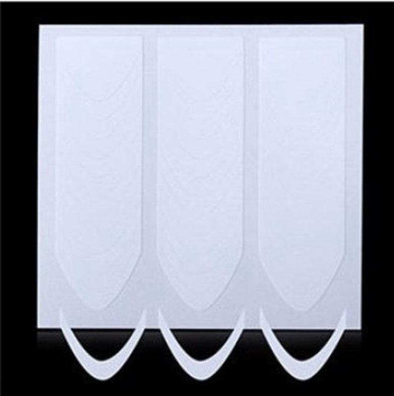 May include: Three white nail guide stickers on a white background. The stickers are shaped like a crescent moon and have a textured surface.