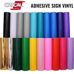 May include: A variety of colors of adhesive sign vinyl rolls. The rolls are arranged in two rows. The colors include black, white, gray, teal, blue, purple, gold, silver, green, yellow, pink, red, and lavender.