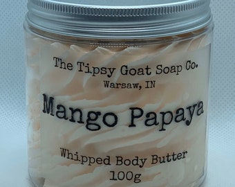 May include: A white jar with a silver lid filled with a whipped body butter. The jar has a label that reads "The Tipsy Goat Soap Co. Warsaw, IN" and "Mango Papaya Whipped Body Butter 100g".