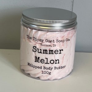 May include: A white jar with a silver lid filled with pink whipped body butter. The jar has a label that reads "The Tipsy Goat Soap Co. Warsaw, IN Summer Melon Whipped Body Butter 100g"