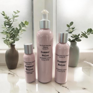 May include: Three bottles of Summer Melon scented lotion in different sizes. The bottles are pink and have silver lids. The largest bottle is 8 ounces, the middle bottle is 4 ounces, and the smallest bottle is 2 ounces. The bottles are labelled "The Tipsy Goat Soap Company, Warsaw, IN".