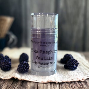May include: A clear plastic tube containing a purple body butter stick. The label reads "The Tipsy Goat Soap Company, Warsaw, IN, Black Raspberry Vanilla Body Butter Stick, 1.25oz (35g)".