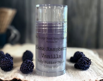 May include: A clear plastic tube containing a purple body butter stick. The label reads "The Tipsy Goat Soap Company, Warsaw, IN, Black Raspberry Vanilla Body Butter Stick, 1.25oz (35g)".
