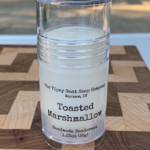 May include: A clear plastic tube with a white deodorant stick inside. The label reads "The Tipsy Goat Soap Company, Warsaw, IN, Toasted Marshmallow, Handmade Deodorant, 1.25oz (35g)"