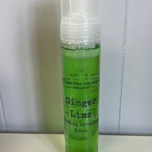 May include: A clear plastic bottle of green foaming hand soap with a white pump top. The label reads "Ginger Lime Foaming Hand Soap 8.5oz" and "The Tipsy Goat Soap Company Warsaw, IN."