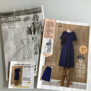 Peut inclure: Image de patrons de couture et d'une page de magazine présentant une robe bleu marine sur un mannequin. Les patrons comprennent des illustrations de la robe et du texte en français. Le magazine montre également la robe et des bottes.