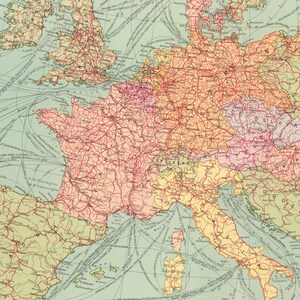 May include: A vintage map of Europe with red lines showing the major railway lines. The map is on a light blue background with yellow, pink, and green colors representing different countries. The map includes the names of major cities and countries.