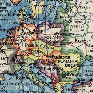 May include: A vintage map of Europe with country borders and major cities labeled. The map is printed on paper with a light blue background and features a variety of colors to distinguish the different countries. The map includes the countries of Norway, Sweden, Finland, Denmark, Germany, Poland, Czech Republic, Austria, Hungary, Romania, Bulgaria, Greece, Turkey, Italy, Switzerland, France, Belgium, Netherlands, and the United Kingdom.
