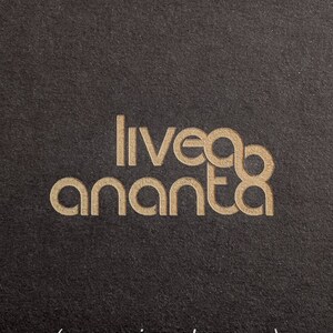 May include: Close-up of an engraved logo on a black surface. The logo reads "liveda ananta" in a gold font.
