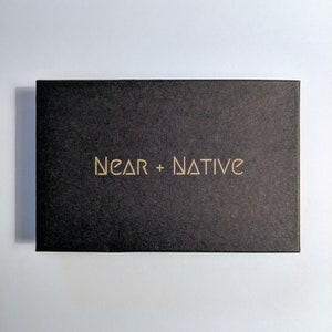 May include: A black box with the text "NEAR + NATIVE" printed in gold on the front.