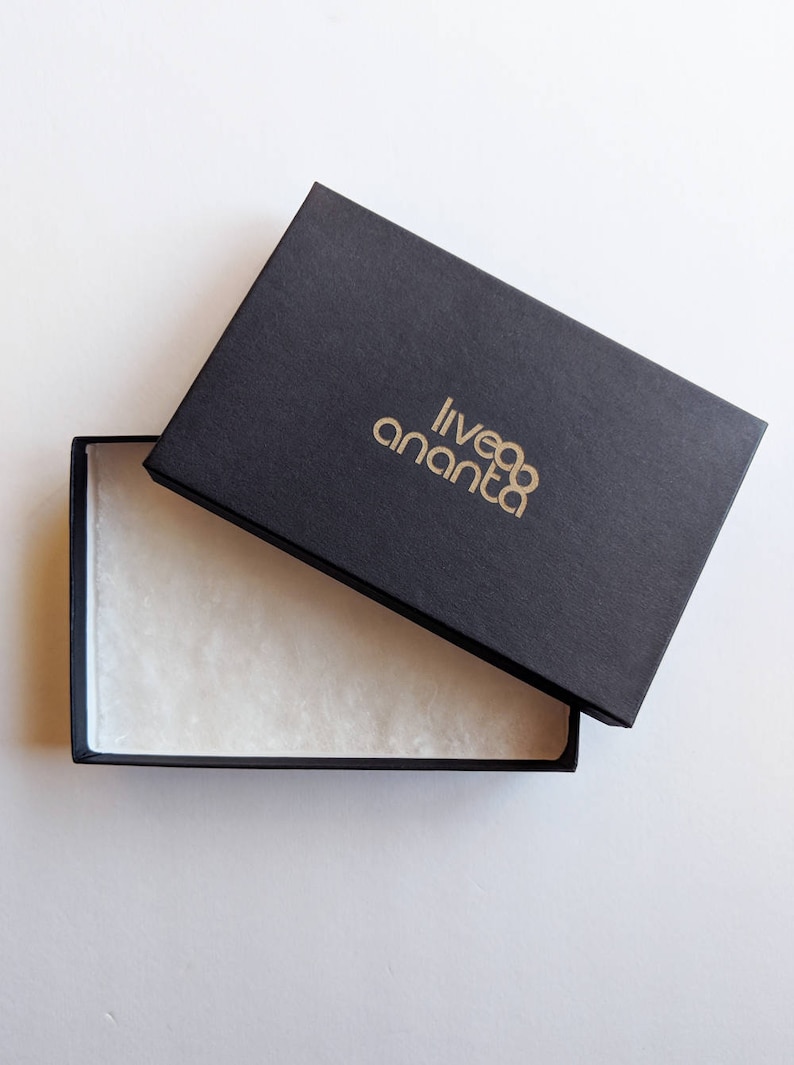 May include: A black box with a gold logo that reads "liveananta" is open, revealing a white tissue paper lining.