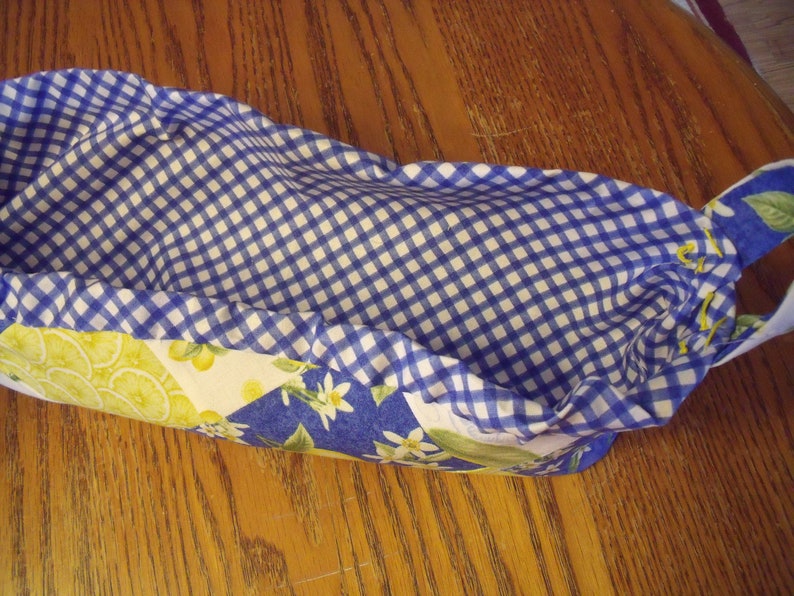 Puede incluir: Una cesta forrada con tela vichy azul y blanca con un estampado de lim&oacute;n y flores en el exterior. La cesta est&aacute; vac&iacute;a y lista para ser llenada.