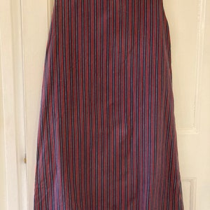 May include: A sleeveless dress with vertical stripes in shades of red, blue, and white.