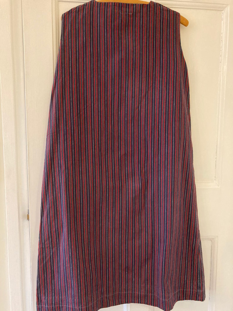 May include: A sleeveless dress with vertical stripes in shades of red, blue, and white.
