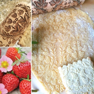 May include: A wooden rolling pin with a carved design of strawberries and leaves. The rolling pin is used to create an embossed pattern on dough, such as cookies or pie crust.