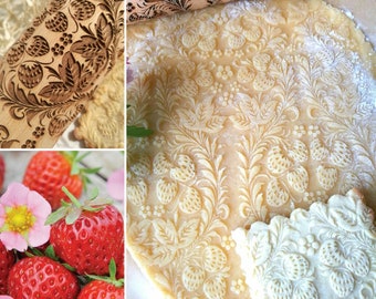 May include: A wooden rolling pin with a carved design of strawberries and leaves. The rolling pin is used to create an embossed pattern on dough, such as cookies or pie crust.