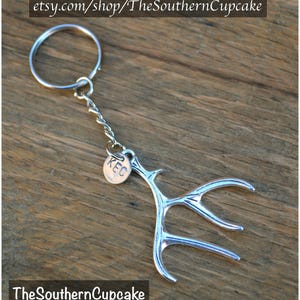 May include: Silver antler keychain with a small round tag that says "KEC".