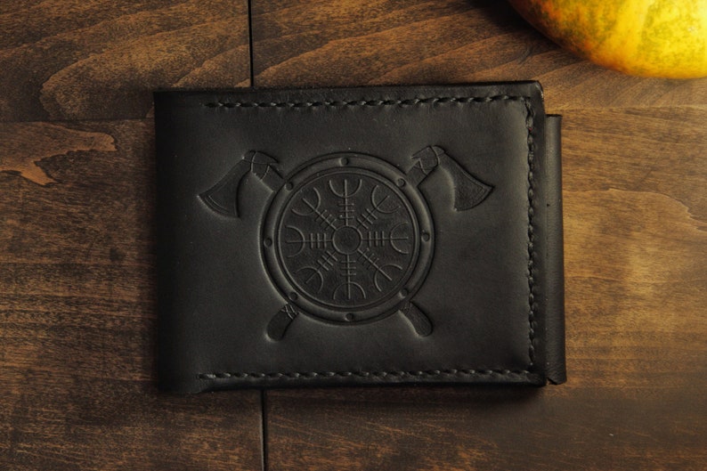 May include: Black leather wallet with a embossed design of a shield and two axes.